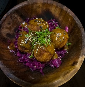 Sausage balls on red cabbage, drizzled with a sweet sauce